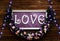 Love inscription on a wooden background, flashing lights and flowers. Decorative artistic animation devoted to the