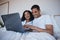 Love, laptop and happy couple relax in bed, bonding and enjoying streaming, movie or browsing in their home. Online
