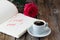 Love letter notepad, red roses and coffee cup on wooden table. Valentines day concept