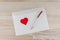 Love mail: the white empty blank envelope for letters, a white ball pen and red heart rests on a linen fabric