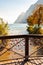 Love and marriage locks hanging on metal grid on wooden railings in Riva del Garda city with beautiful lake waterscape on the