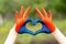 Love Mongolia concept. Little girl show hands in heart form painted in Mongolia flag color. Mongolian patriotism. July