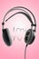 Love music lifestyle concept. Wireless black headphones with cardiogram and heart isolated on pink background