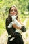 Love nature. Happy smiling girl with lamb on a countryside. Young woman hugging a small goatling at farm.