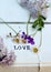 Love note, lilac and  daisies on white wooden crate