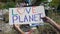 Love planet phrase on cardboard in person hands against landfill background