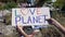 Love planet phrase on cardboard in person hands against landfill background