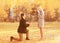 Love, relationships, engagement and wedding concept - kneeled man proposes a woman to marry, red box ring, happy romantic couple