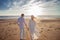 Love, romance on the beach. Young beautiful couple, woman, man, in white loose flying clothes, walk, along the seashore.