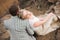 Love, romance and people concept - happy young couple hugging sitting on the edge of a cliff outdoors.