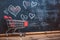 Love for shopping Small cart, heart doodles on charming blackboard