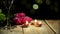 Love still life in macro made of burning candles and flowers lying next to grape with wineglasses