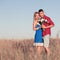 Love story. Beautiful young couple walking in meadow, outdoor