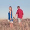 Love story. Beautiful young couple walking in meadow, outdoor