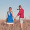 Love story. Beautiful young couple walking in meadow, outdoor