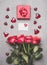 Love symbols composing with red gift box, ribbon, roses bunch , blank white paper card and heart, top view.