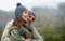 They love taking in the mountain views. A happy young couple enjoying the sights while hiking through the mountain.