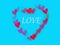 Love text in red hearts bokeh in heart shape romance frame isolated on blue