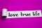 Love True Life text, Inspiration, Motivation and business concept on purple torn paper