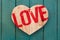 Love Valentines message wooden heart on turquoise painted background