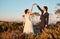 Love, wedding and holding hands for dance with couple in nature park for celebration, romance and happiness. Sunset