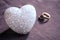 Love, wedding and Valentine`s day concept. Beautiful golden wedding rings and glass heart selective focus. useful as greeting card