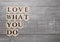 Love what you do motivation symbol on wood board