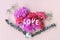 Love wooden word on fresh carnation flowers