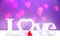 Love word on blurred hearts background.Valentine`s day background