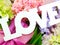 Love word copy with gift and flower close up background