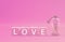 Love word , Text on wooden block object on pink background and copy space - Pink Valentine celebrate concept