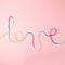 Love word written with woolen thread lettering, concept and background for Valentine`s Day, copy space.