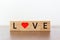 Love written on wooden cubes against white background