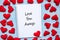 LOVE YOU AWAYS word on notebook with pink heart shape decoration on blue wooden table background. Wedding, Romantic and Happy