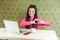 Love you! Portrait of romantic happy young girlfriend with black dreadlocks hairstyle in pink blouse sitting in cafe and showing