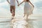 Love young couple barefoot running on the beach. Holiday and vocation concept