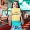 Love yourself. Cropped portrait of an attractive young woman holding up a sign in a retro diner.