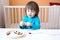 Lovely 2 years boy plays with beads of various colours