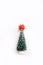 Lovely artificial mini Christmas tree with red bow on top over white background. Little Christmas tree