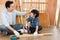 A lovely Asian father is teaching his son woodworking