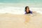 Lovely Asian little girl plays alone on beach with sea wave and she look very happy and fun