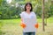 Lovely Asian teen girl with white t-shirt holds white box filled with plastic bottle stand in the green garden with the concept of