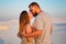 Lovely attractive couple kissing on the white sand beach or in the desert or in the sand dunes, happy couple embracing at the beac