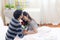 Lovely attractive young Asian couple man give rose and kiss forehead of happy and smile woman in romantic moment in bedroom. Lover