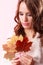 Lovely autumnal girl with maple leaves in hand