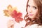 Lovely autumnal girl with maple leaves in hand