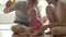 Lovely baby girl sitting on floor with parents and playing