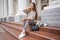 Lovely beautiful stylish woman sitting on street stairs with legs crossed