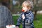 Lovely blond boy of two years eating strawberries outdoors