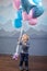 Lovely boy the blonde plays with balloons. Laughing boy and balloons